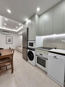 Una cocina con estufa, lavadora y secadora. en AeroSuites102 Alojamiento Madrid, en Madrid