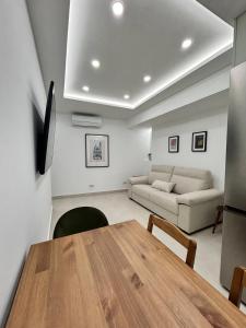 una sala de estar con una mesa y un sofá en AeroSuites102 Alojamiento Madrid, en Madrid