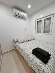Un dormitorio con una cama con una bolsa negra. en AeroSuites102 Alojamiento Madrid, en Madrid
