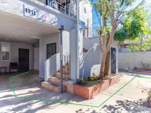 a house with a staircase and a tree in a yard at Modern 3 Bedroom Apartment in San Fernando in San Fernando
