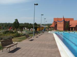 a row of benches next to a swimming pool at Kis Teniszház in Ordacsehi