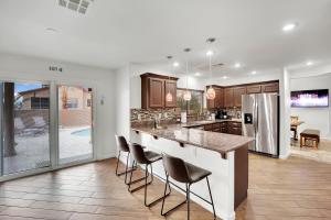 une cuisine avec un grand îlot et des tabourets de bar dans l'établissement Heritage Haven Villa, à Las Vegas
