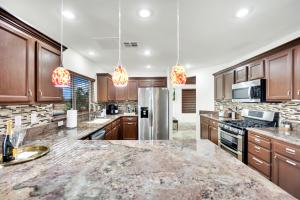 une cuisine avec des armoires en bois et des appareils en acier inoxydable dans l'établissement Heritage Haven Villa, à Las Vegas 60 autres photos
