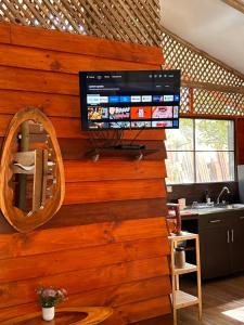 a television on a wooden wall in a kitchen at Casa LORA Eco nature retreat in Bagaces in Bagaces