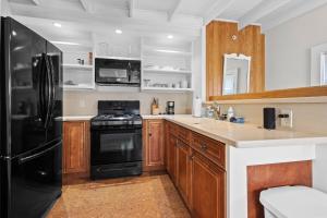 a kitchen with a black refrigerator and a sink at The Old Apartment in Fort Pierce