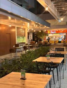 Un restaurante con mesas y sillas de madera en un edificio. en Flat Luxury Metropolitan Sidney, en Goiânia