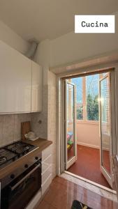 a kitchen with a stove and a sliding glass door at Sweet Rome Ipogeo Degli Ottavi in Rome