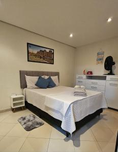 a bedroom with a large bed with blue pillows at Apartamento Bandeiras Local Tranquilo e Familiar in Osasco