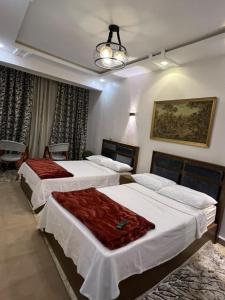 a bedroom with two beds and a chandelier at Moonlight golf view in Cairo