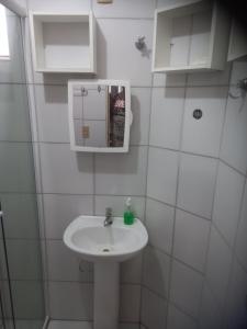 a white bathroom with a sink and a mirror at Pousada Victor - Arte in Manaus +12 photos