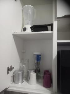 a kitchen shelf with a bunch of kitchen utensils at Pousada Victor - Arte in Manaus