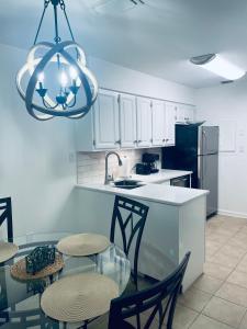 a kitchen with white cabinets and a table and chairs at The Bromeliad at Turtle Cove Villas in Kiawah Island +28 photos