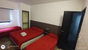 a small room with two beds and a window at Parque Chacabuco in Mar del Plata