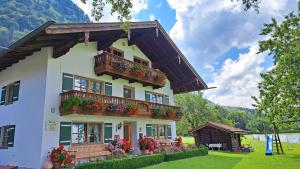 a house with a balcony and flowers on it at Schusterhof in Marquartstein