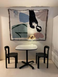 een tafel en twee stoelen en een kleed aan een muur bij Stay early mansion in Incheon