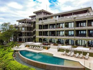 a hotel with a swimming pool in front of a building at 360 Splendor 101B Ocean View Studio With Breakfast in Playa Flamingo