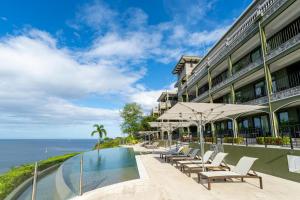 a hotel with a swimming pool next to the ocean at 360 Splendor 101B Ocean View Studio With Breakfast in Playa Flamingo