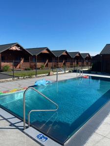 a swimming pool with blue water in a house at Osada Lekranka in Kopań