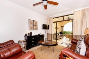 a living room with leather furniture and a ceiling fan at Sunrise 27- 2 Bedroom Ocean View Condo in Tamarindo