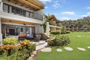 a house with a patio and a yard at Palms 26 Sueños Del Sol in Playa Flamingo
