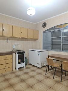 a kitchen with a table and a table and chairs at CASA - 3 quartos com ar - garagem para 3 carros in Campo Grande