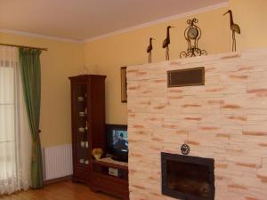 a living room with a stone fireplace with a tv at Apartament 12 Zacisze - Apartamenty Pod Aniołem in Kazimierz Dolny