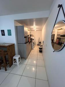 a room with a hallway with a mirror and a kitchen at Condomínio residencial mar azul in Imbituba +20 photos