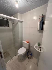 a bathroom with a toilet and a shower and a sink at Condomínio residencial mar azul in Imbituba