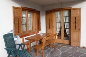 a dining room with a wooden table and two chairs at Appartamento Zorzi in Ziano di Fiemme +6 photos