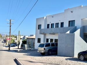 a van parked in front of a white building at Departamento #1 Loma Bonita in Loreto