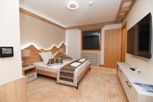 a bedroom with a bed and a flat screen tv at Apartman D343 Aparthotel Vucko Jahorina privat apartman in Jahorina