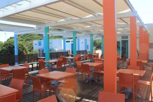 an empty cafeteria with tables and chairs on a deck at Serra Degli Alimini 2 in Alimini