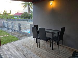 a black table and chairs on a deck at Appartement cosy et lumineux in Les Abymes