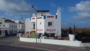 um edifício branco ao lado de uma rua em Alex Surf Hostel no Baleal
