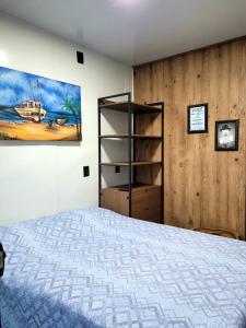 a bedroom with a bed and a painting on the wall at POUSADAGiraGarden Containers in Arroio do Silva