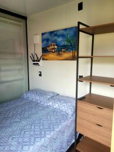 a bedroom with a bed and a book shelf at POUSADAGiraGarden Containers in Arroio do Silva