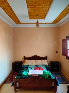 una camera da letto con un letto con soffitto in legno di Maison d'accueil Wakrim a Tafraout
