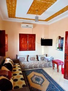un soggiorno con divano e TV a schermo piatto di Maison d'accueil Wakrim a Tafraout