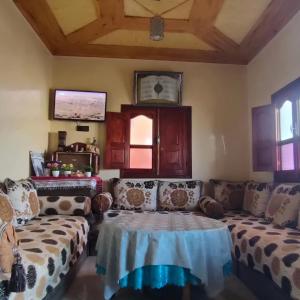 un soggiorno con divani e un tavolo in una camera di Maison d'accueil Wakrim a Tafraout Altre 25 foto