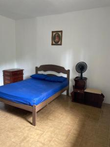 a bedroom with a bed with a blue comforter at Casa em Camburi, Sertão do Piavu in São Sebastião
