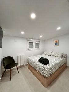 a bedroom with a bed and a chair at AeroSuites201 Alojamiento Madrid in Madrid