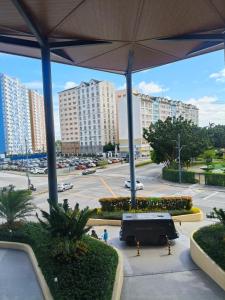 a bus parked in a parking lot with tall buildings at Tessa's Place Staycation in Biñan