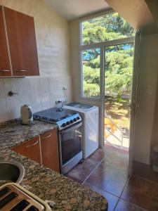 una cocina con estufa horno superior al lado de una ventana en Beautiful Casa Madrynense, en Puerto Madryn