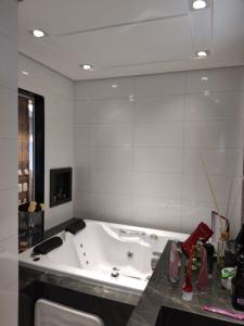 a bathroom with a tub and a large mirror at Apartamento grande in Caxias do Sul