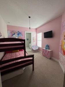 a bedroom with a bunk bed and pink walls at Disney here we go in Orlando +36 photos