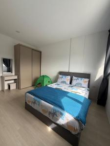 a bedroom with a bed with a blue comforter at 2BR Apartment Near Kuching Airport in Kuching +6 photos