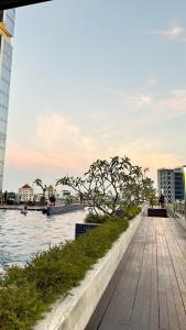 a walkway next to a body of water with buildings at Zahra Sea View 2BDR Apartment Pollux Habibie Batam in Batam Center +34 photos