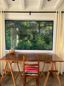 una mesa de madera y una silla frente a una ventana en Casa Luz de Campo, en Guerrero