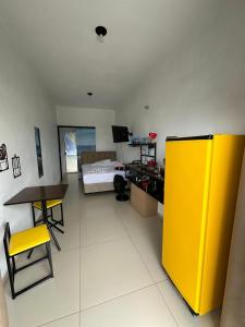 a room with a bed and a desk and a yellow wall at Pousada Mar e Chaves in Penha +29 photos
