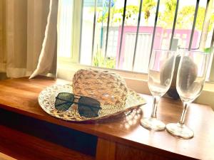 a hat and glasses sitting on a table with a window at Guest House Rosa do Mar in Olinda
